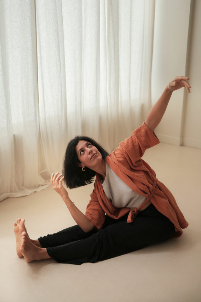 May Ben Osman, assise par terre, regard vers le ciel. Site de Empreinte : communication et mentoring pour prof de yoga en France et à l'étranger